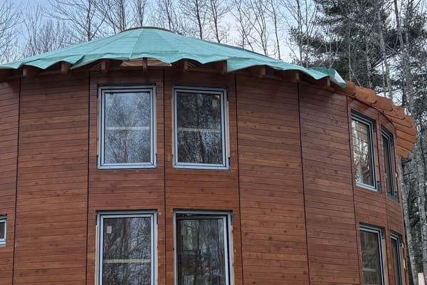 The upper walls and windows with the roof deck wrapped in green membrane against the winter