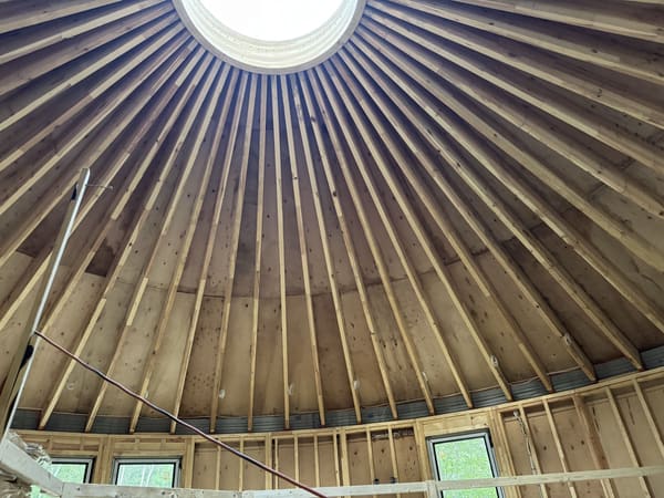 Looking up at the rafters converging on the open ring at the crown, before the dome is set