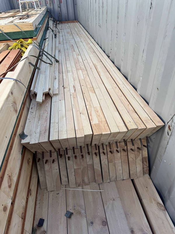 A stack of notched rafters inside the container with the notched ends facing the camera
